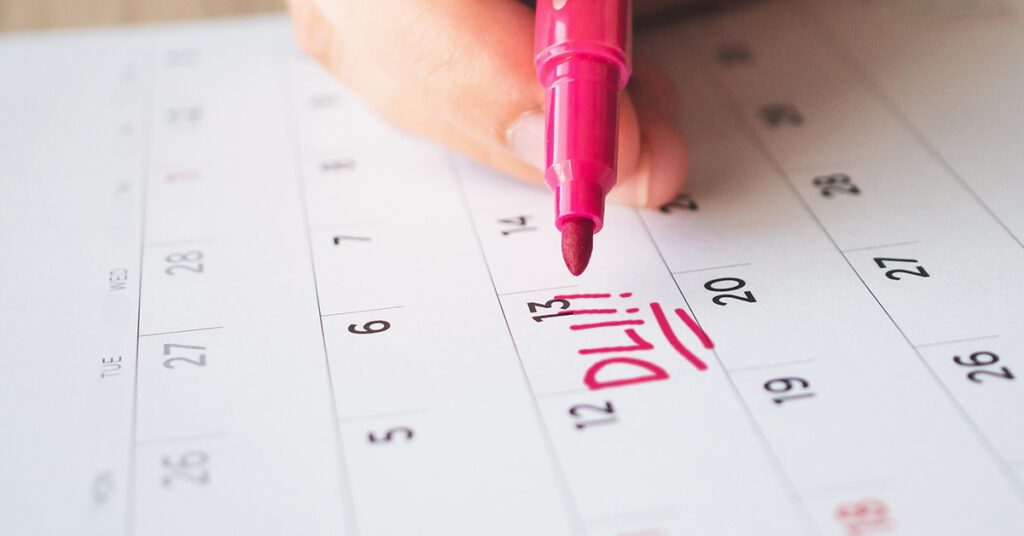 A person marking in red pen the Date Last Insured on a calendar for their SSD benefits.